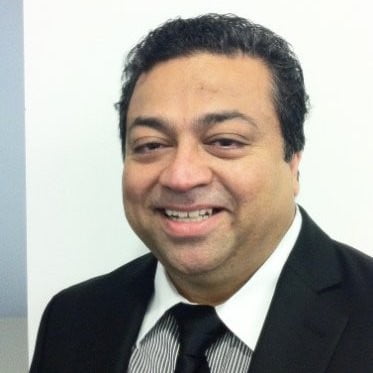 A man in a suit and tie smiling.