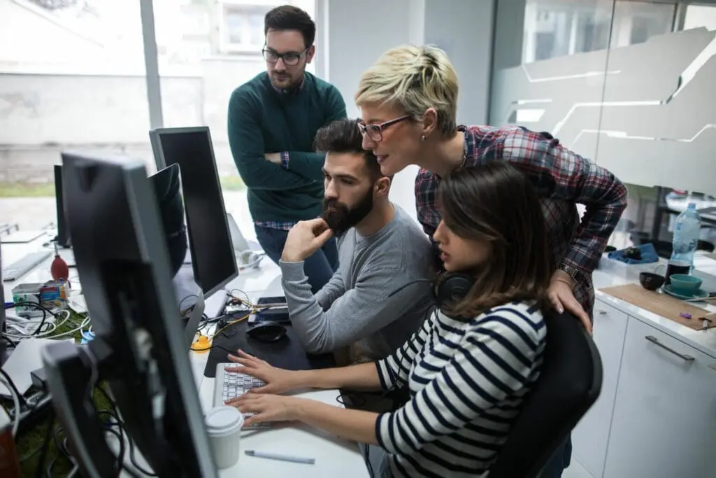 A group of people looking at a computer screen.